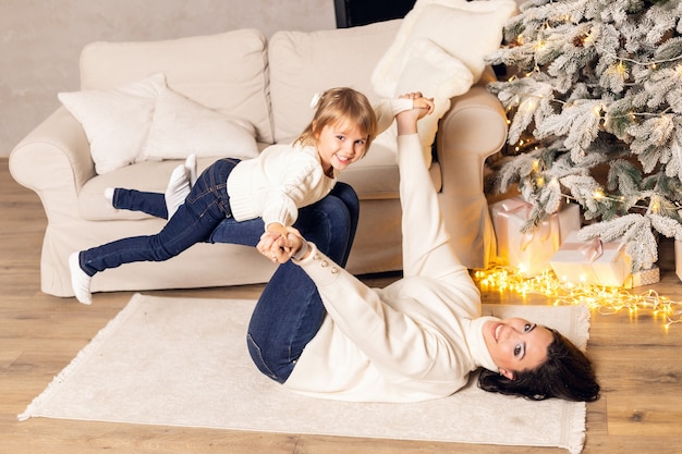 Mother and little child having fun and playing together at home.