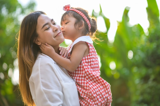 Mother and little daughter playing together in a park.Happy mom and daughter