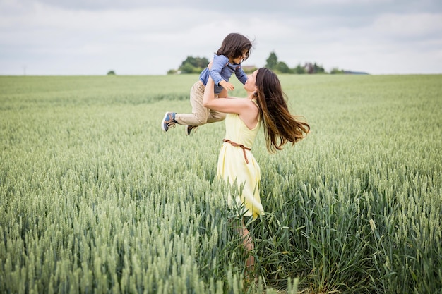 Mother and little eastern handsome baby boy walking in the field