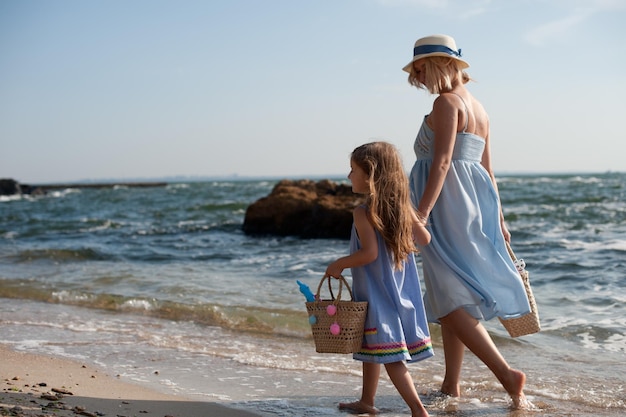 Mother and little girl hiking near sea