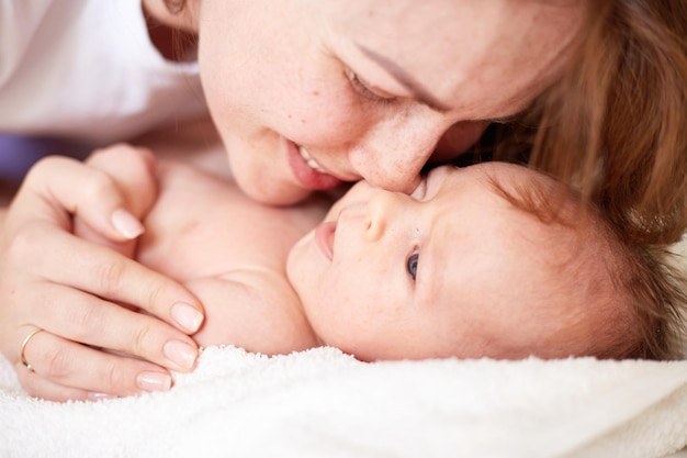 Mother Massaging Her newborn baby boy Realistic home portrait