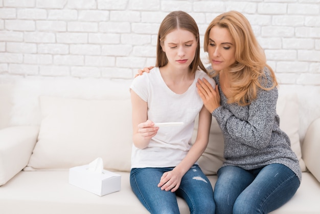 Mother near Upset Daughter with Pregnancy Test.