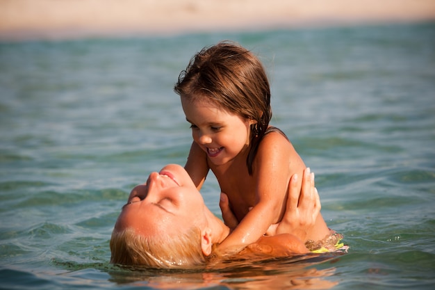 Mother playing in the water with her daughter