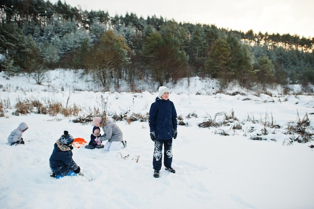 Mother playing with children in winter nature. Outdoors in snow.