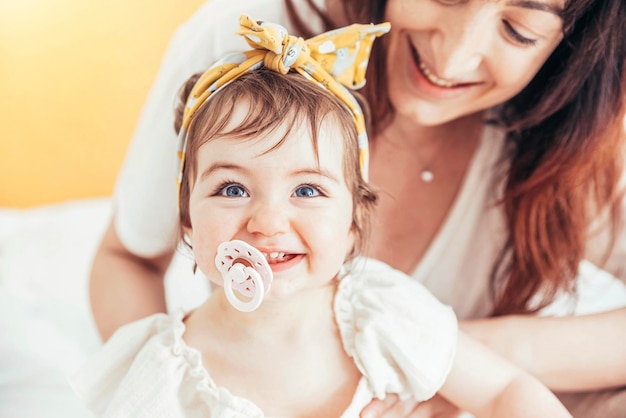 Mother playing with her baby at home Happy loving family concept