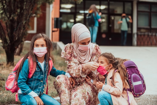 The mother prepares two girls for school Back to school at the time of the coronavirus pandemicNew normal Education during the Covid19 pandemic Selective focusHigh quality photo