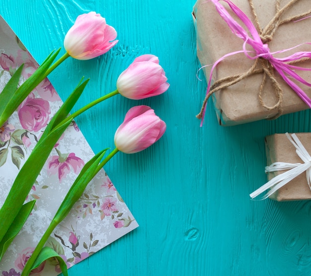 Mother's Day. Pink tulips and presents on blue background