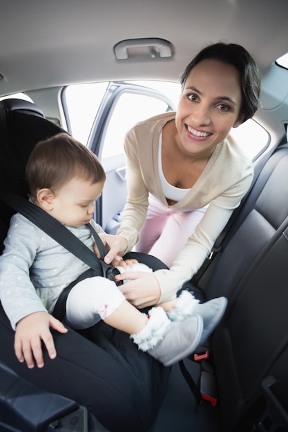 Mother securing her baby in the car seat