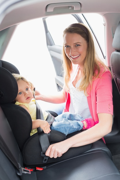 Mother securing her baby in the car seat