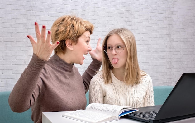 Mother shouts at teenage daughter, daughter shows tongue