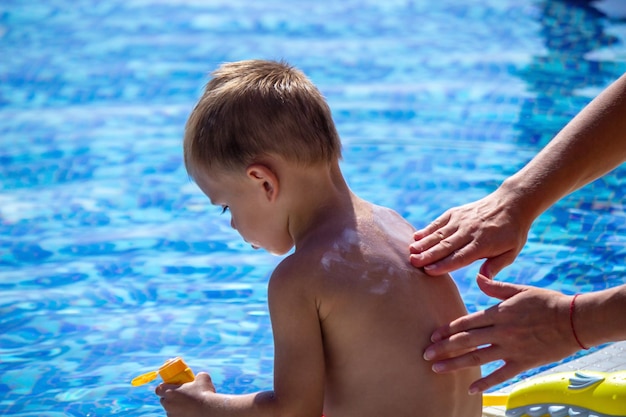 Mother smears the child with sunscreen