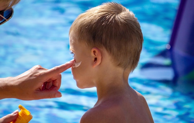 Mother smears the child with sunscreen