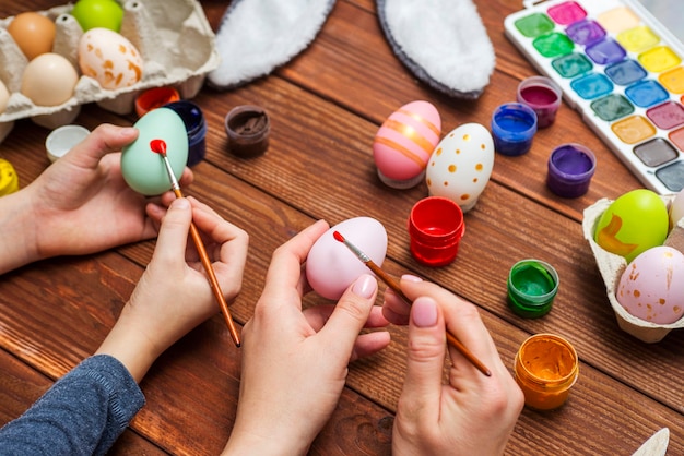 Mother and son are painting Easter eggs