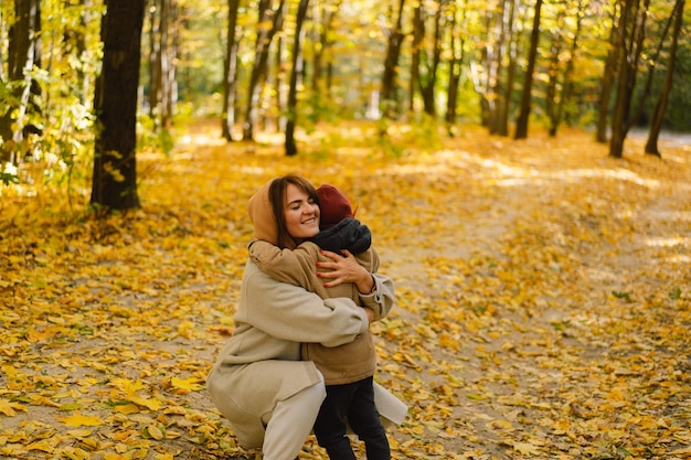 Mother and son are walking in the autumn forest autumn outdoor activity for family with kids