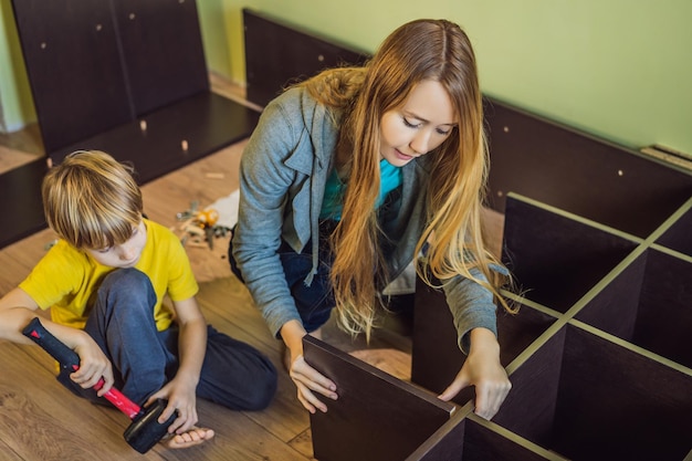 Mother and son assembling furniture Boy helping his mom at home Happy Family concept