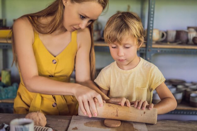 Mother and son doing ceramic pot in pottery workshop