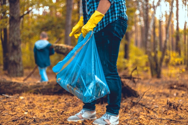 Photo mother and son eco activists collect garbage in the forest the family takes care of saving the fores