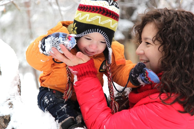 Mother and son playing and laughing in winter park