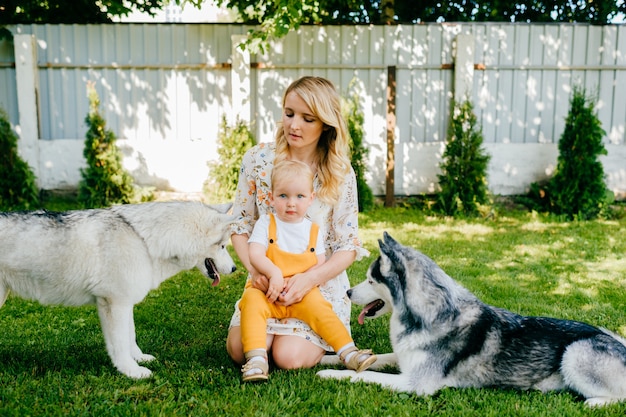 Mother and son posing with two dogs in the garden