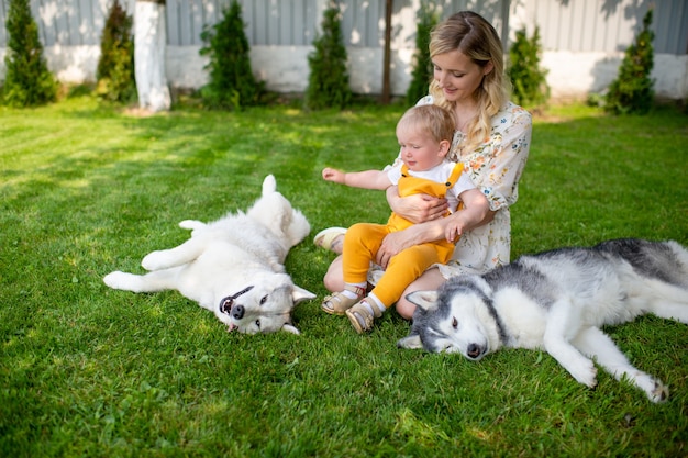 Mother and son posing with two dogs on the grass