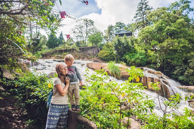 Mother and son on the surface of Beautiful Camly waterfall In Da Lat city,