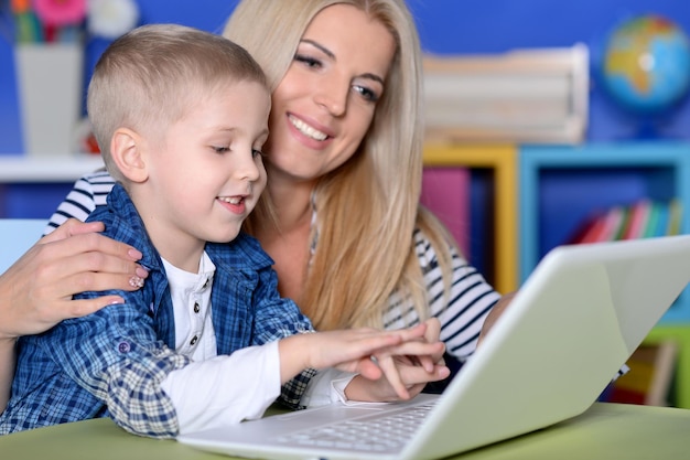 Mother and son using modern laptop