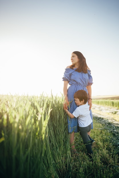 Mother and son walking on wheat field