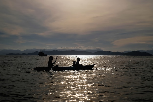 mother and sons rowing kayak in the sea on vacation