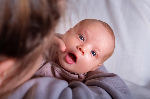 Mother stroking face her newborn baby girl