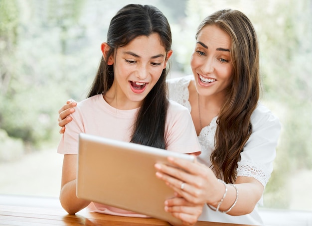 Mother tablet and child looking excited about learning together on an educational app Parent support and caring for your kids future goals Mom bonding with daughter while teaching her online