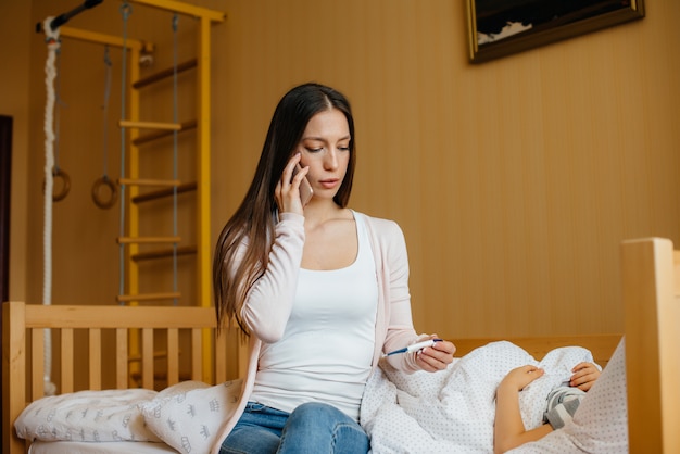 A mother takes care of her child who has a fever and fever. Disease and healthcare