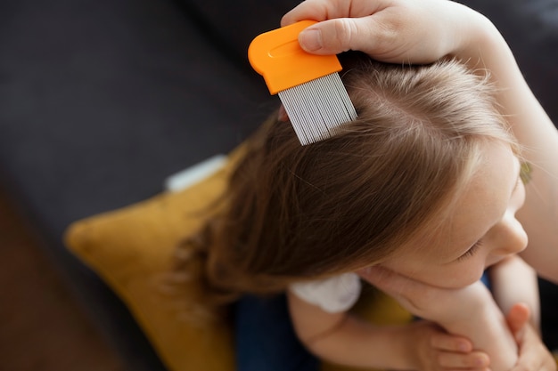 Mother taking care of child with head lices