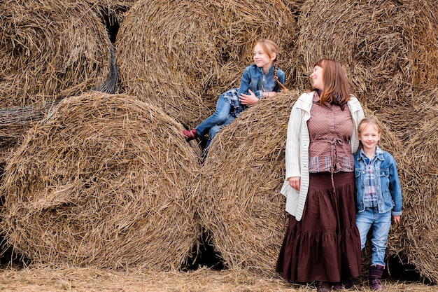 the mother and two daughters are resting near the hay