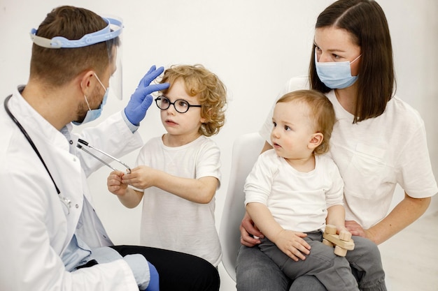 Mother and two her sons have an appointment with pediatrician