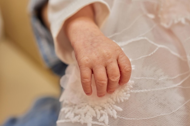 Mother uses her hand to hold her baby's tiny hand to make him feeling her love warm and secure