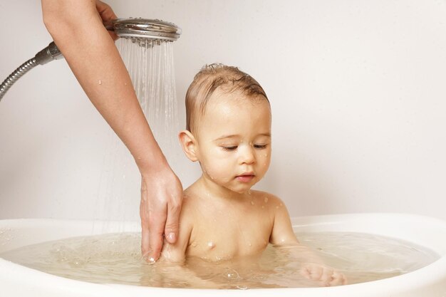 Mother washing and showering her little son