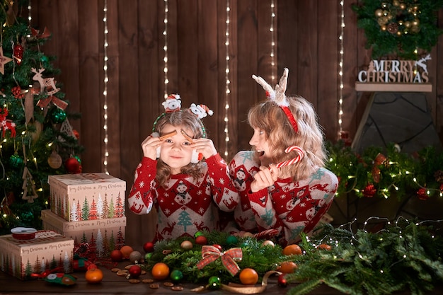 Mother with child girl near christmas tree.