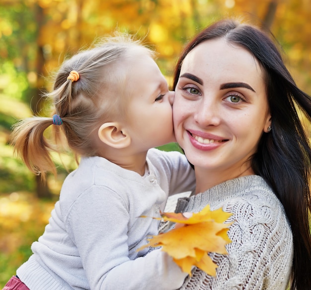 mother with daughter in autumn park