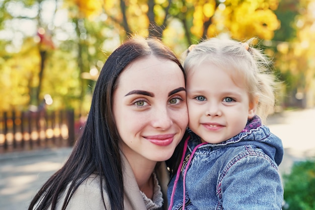 mother with daughter in autumn park