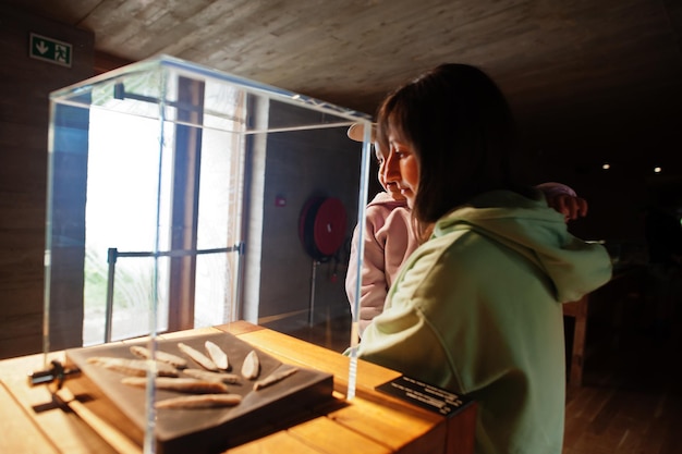 Mother with daughter exploring expositions in museum halls