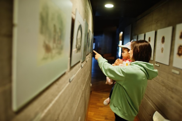 Mother with daughter exploring expositions in museum halls