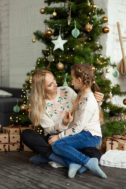 Mother with daughter near the Christmas tree