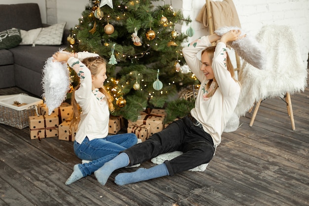 Mother with daughter near the Christmas tree