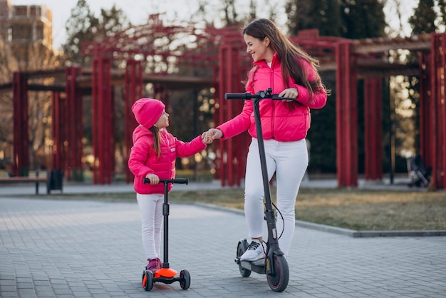 Mother with daughter riding electric scooter