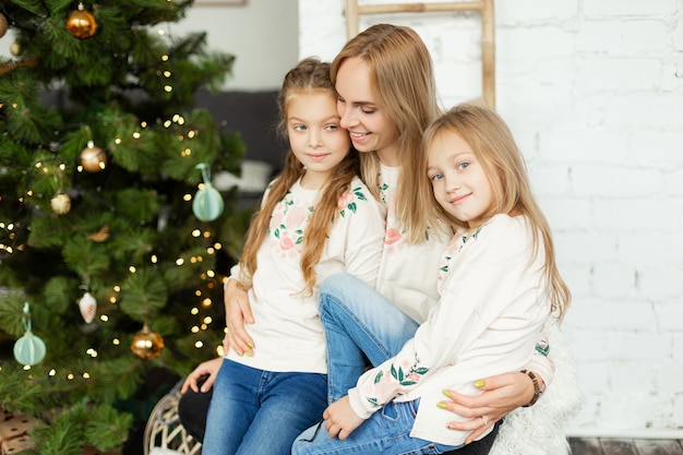 Mother with daughters near the Christmas tree