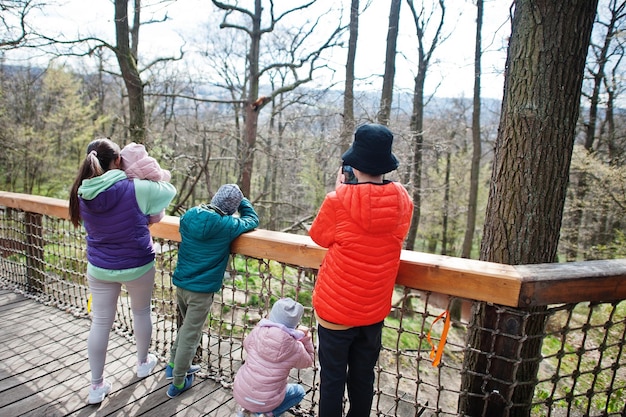 Mother with four kids discovering and watching animals at zoo