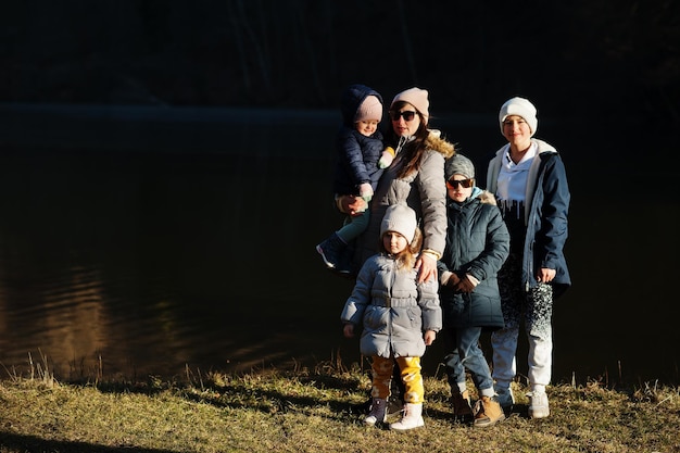 Mother with four kids in pound at early spring park