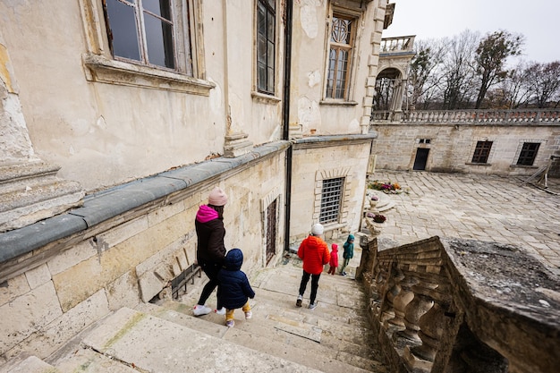 Mother with four kids walking on stairs visit Pidhirtsi Castle Lviv region Ukraine Family tourist