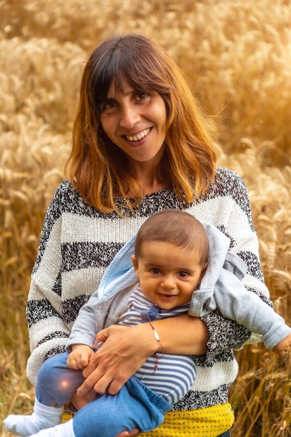 A mother with her baby in a field of yellow straw in French Brittany in the summer