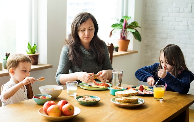 Mother with her children eating breakfast